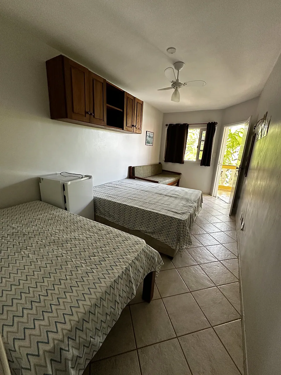 Quarto com duas camas e porta para a varanda