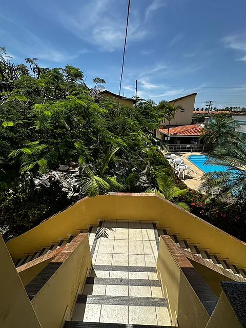 Vista do alto da escada para o jardim e a piscina