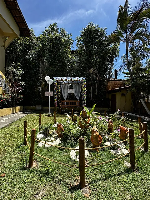 Jardim com caramanchão branco e canteiro decorado
