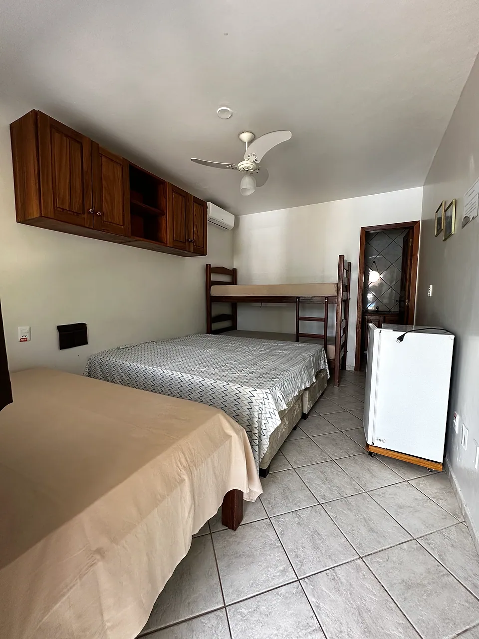 Quarto com cama de casal, beliche e frigobar
