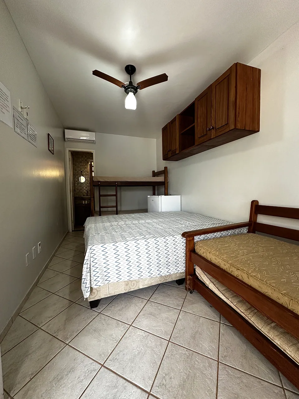 Quarto com cama de casal, bicama, beliche e ventilador de teto