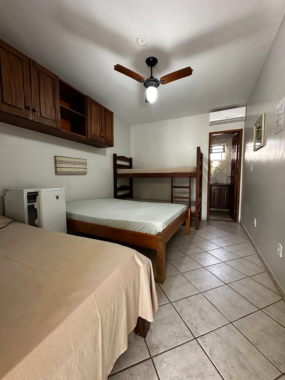 Quarto com cama de casal, beliche e frigobar